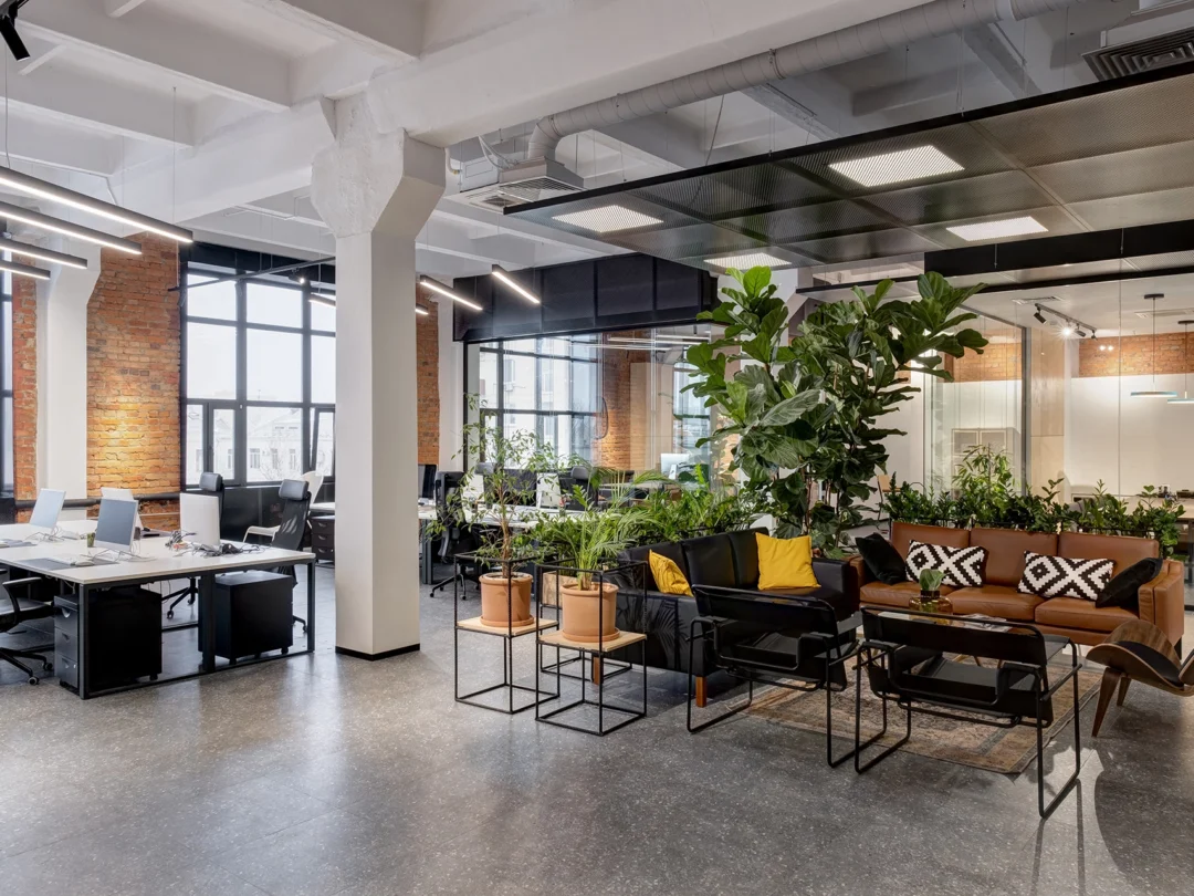 A vibrant open office space filled with various plants and modern furniture, promoting a fresh and inviting atmosphere.